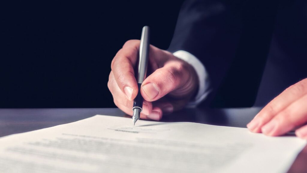 Photo of hand signing executive orders on education
