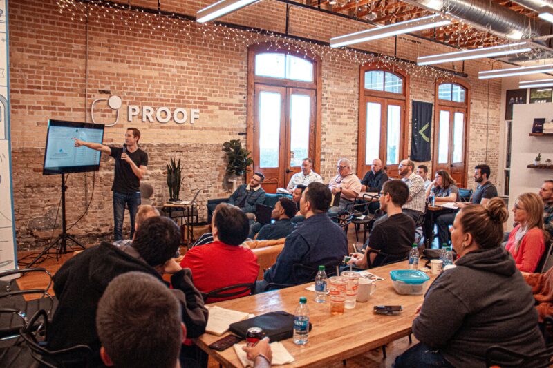 A corporate trainer stands in front of a class of people