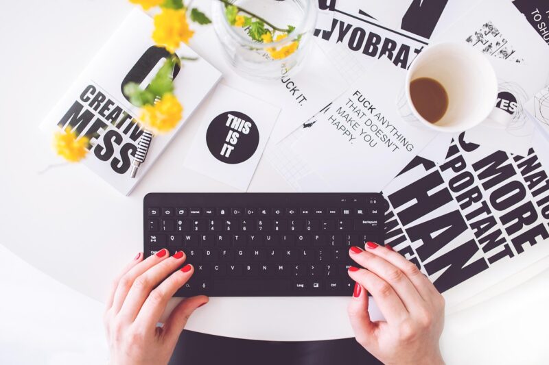 fingers on a keyboard with signs in background for writing career example 