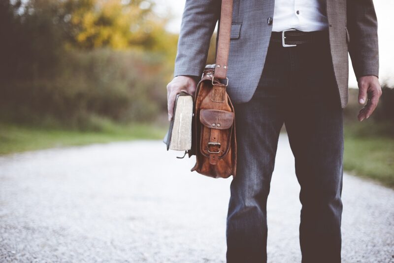 man holding bag and book 
