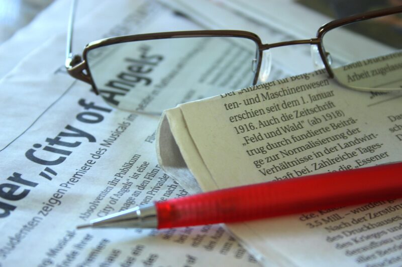 newspaper with pencil and glasses 