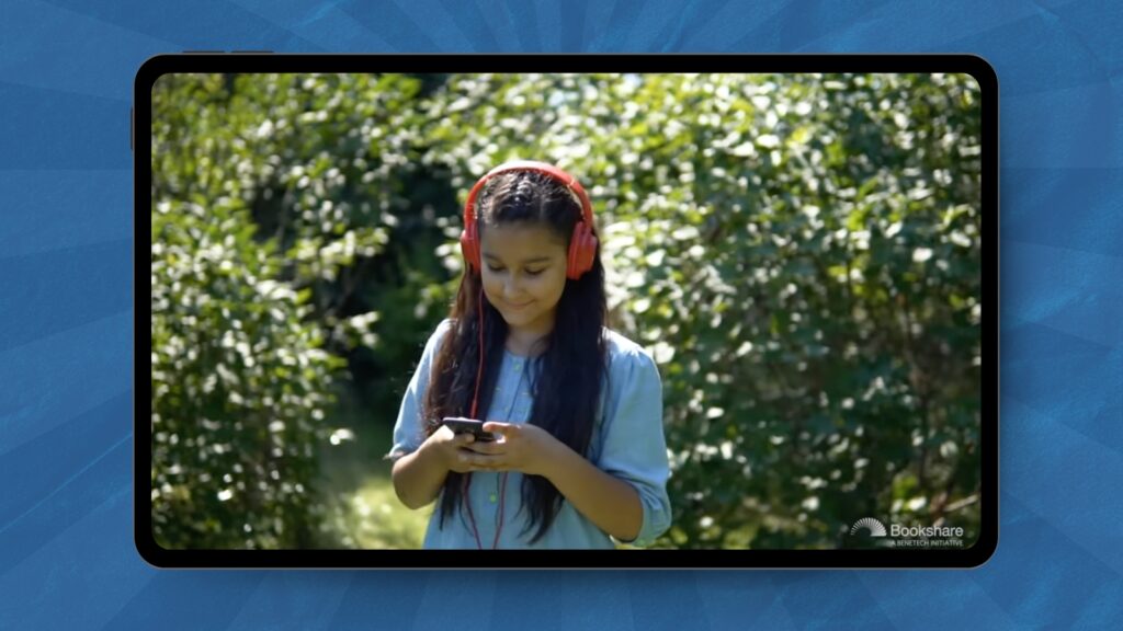 tween looking at her phone with headphones on