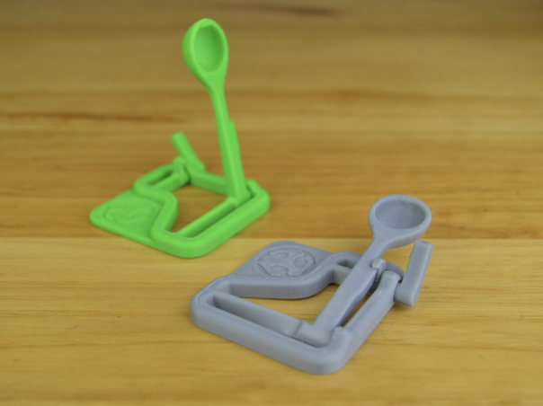 Small green and grey 3d printed catapult toys as an example of 3D printing ideas