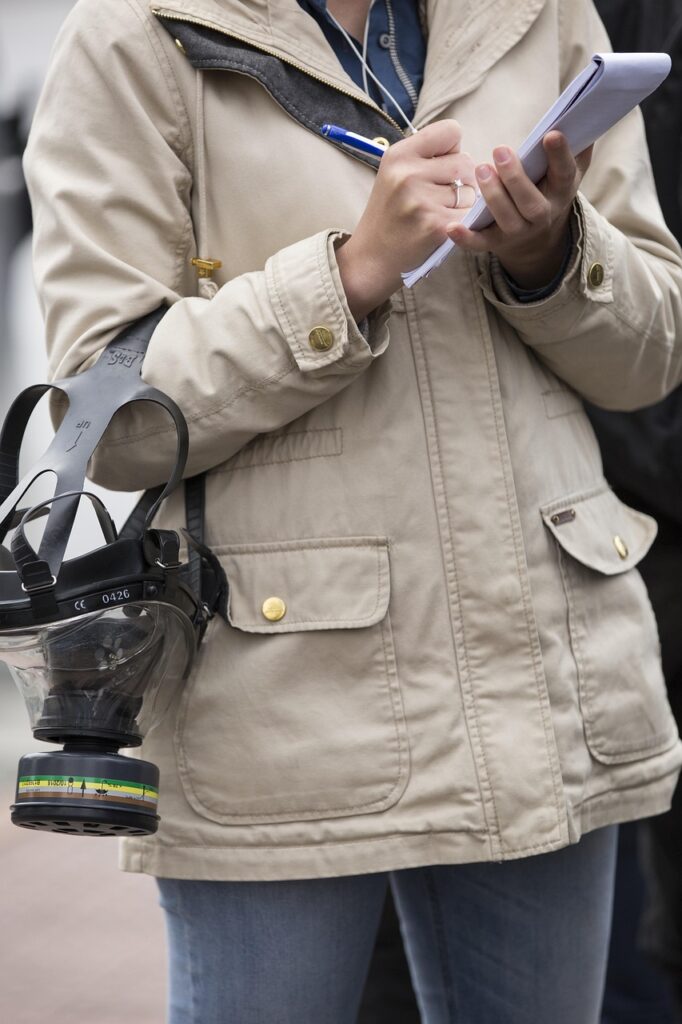 person in coat holding notebook for writing careers 