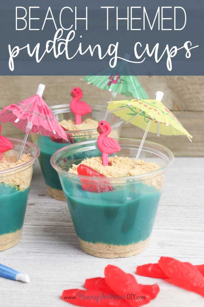 beachsnack Little cups are filled with blue pudding and graham cracker crumbs. They have flamingos and little umbrellas in them.