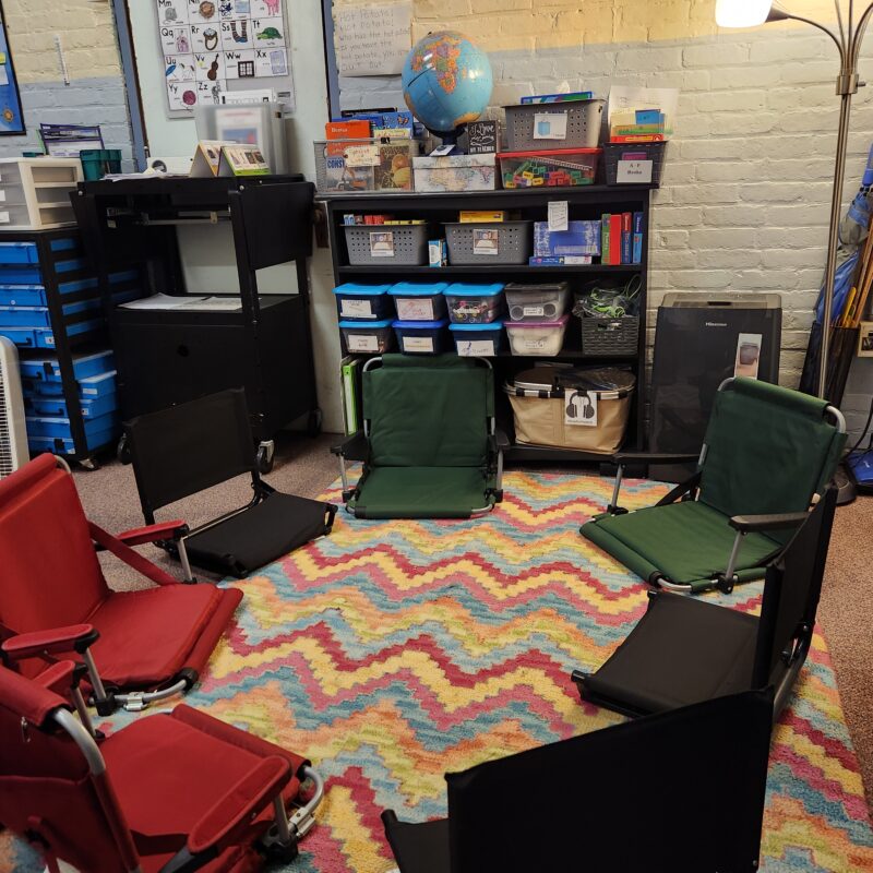 20240614_115318-Gisele-Maloney Cozy discussion area in classroom with rug and seating.