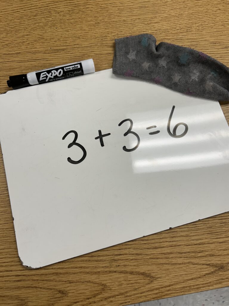 whiteboard whiteboard with writing and a sock for erasing