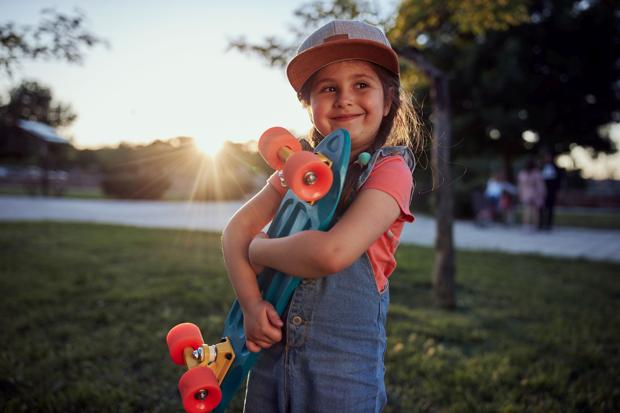 Picture Writing Prompts; Skateboard Girl Cute little girl holding her small skateboard in a public park during sunset