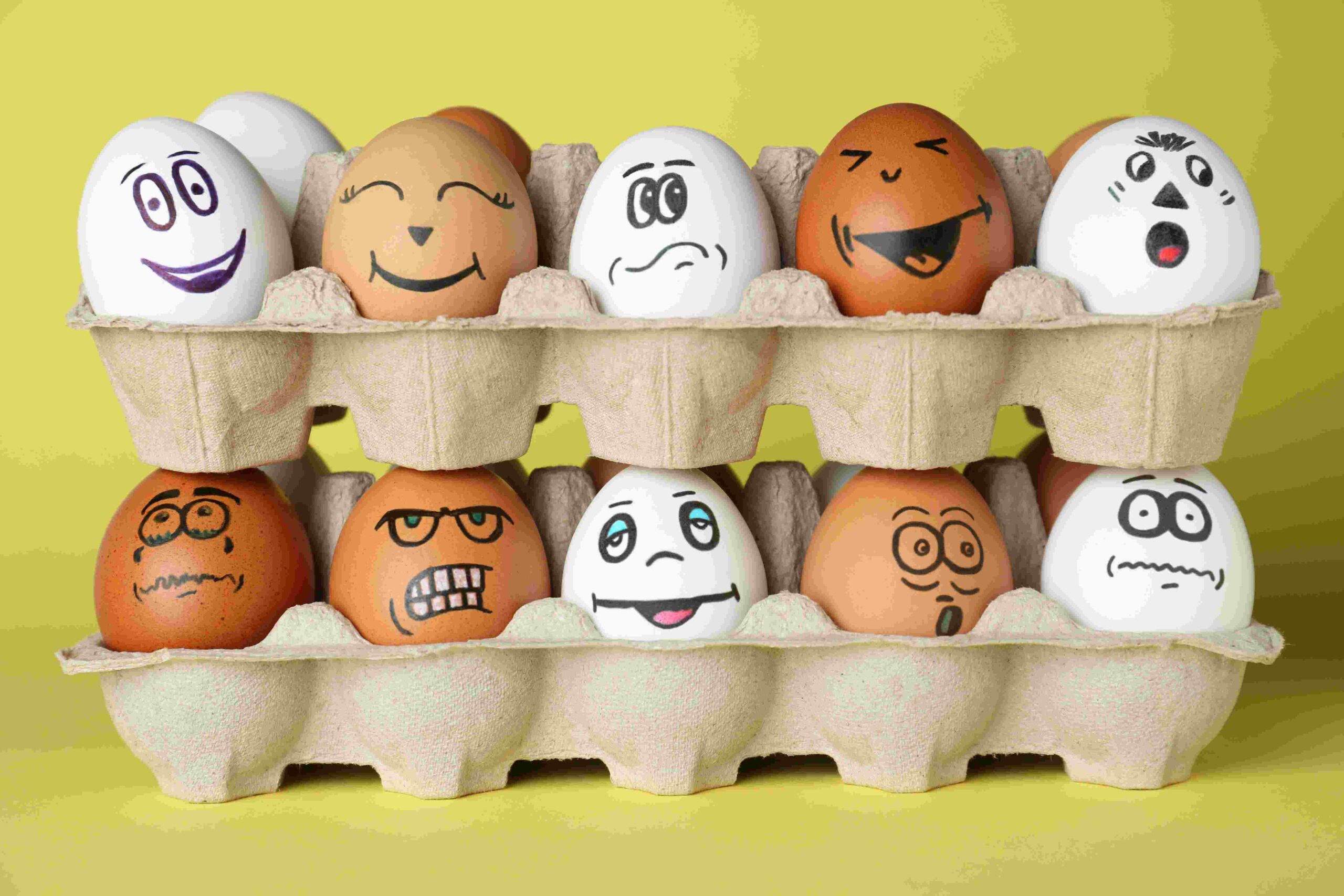 Picture Prompts: Egg Family Eggs with different drawn faces in cardboard packages on pale yellow background