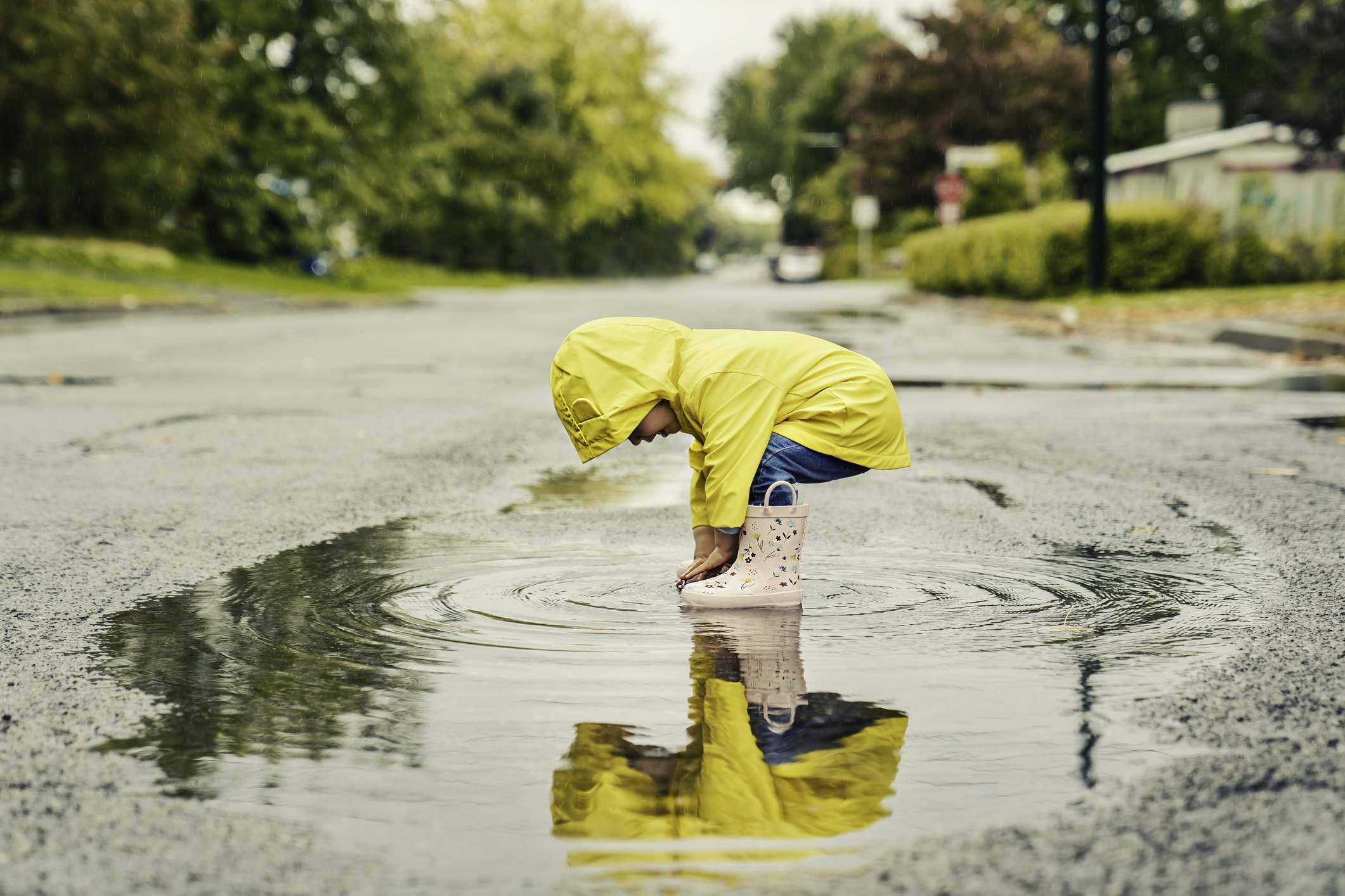 Picture Prompts: Reflection A Funny cute baby girl wearing yellow waterproof coat and boots playing in the rain