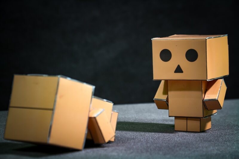 Writing Prompts; Sad Robot Funny robot made of cardboard boxes on dark background. 3d illustration