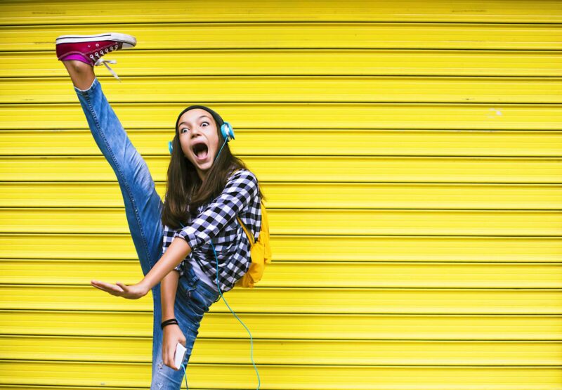 Picture Prompts: Dancing Girl Dancing girl kicking high while standing against a yellow background