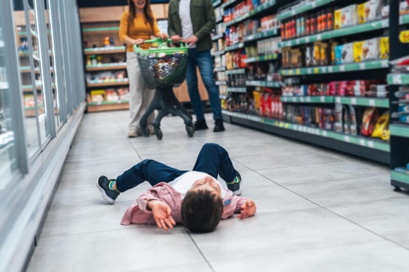 Writing Prompts: Temper Tantrum Shot of small boy lying on floor and fusses while his mom and dad shops for groceries. A capricious child lies on the ground in cry refusing to go. A little boy is lying on the ground in front of his parents and crying.