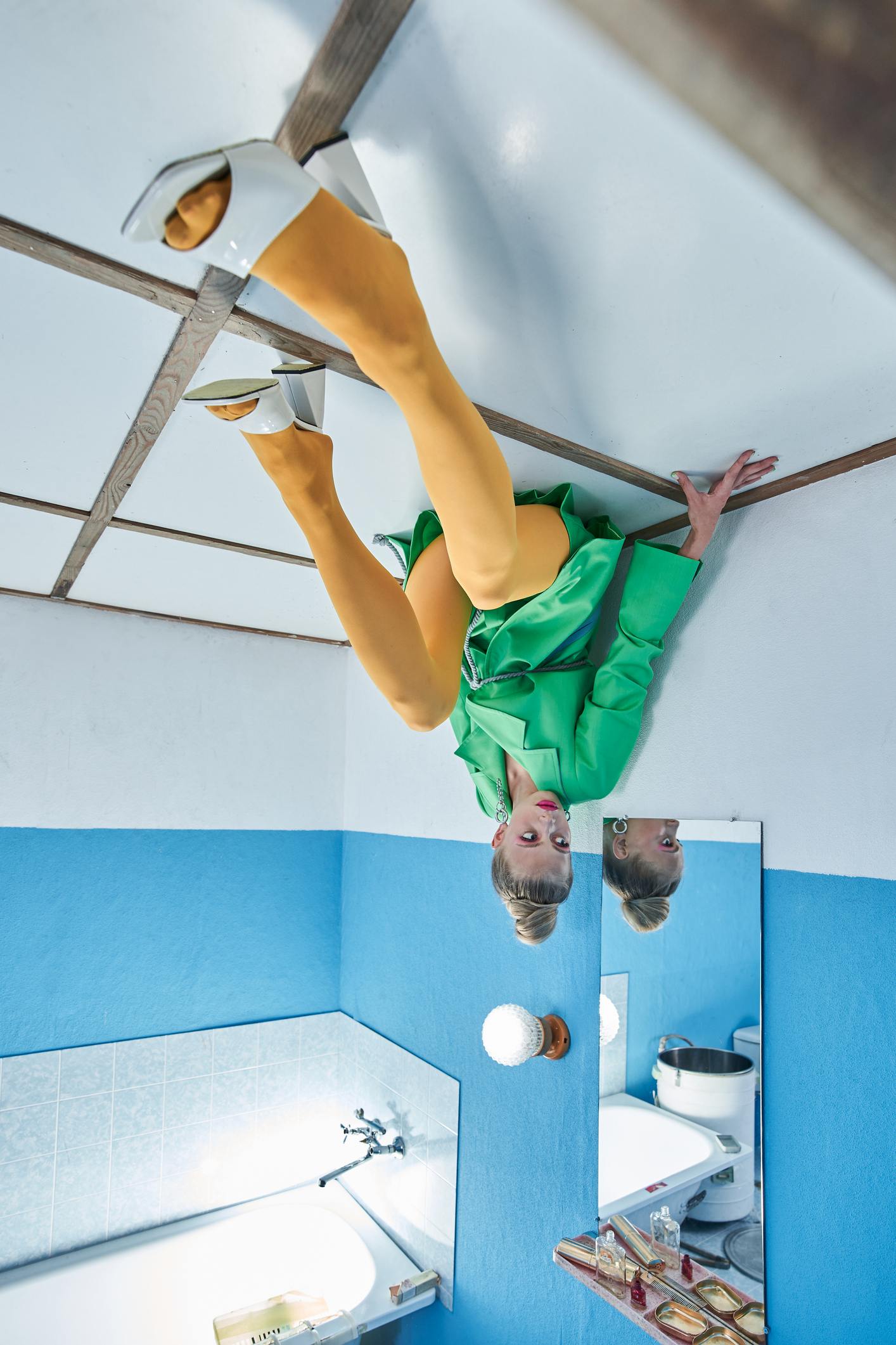 Picture Writing Prompts: Upside Down Upside down view of the female model wearing bright clothes sitting at the ceiling and looking away while posing at the strange studio.