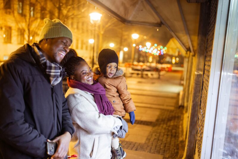 Picture Writing Prompts: Window Shopping A cheerful family of three enjoys a winter evening window shopping in the city.