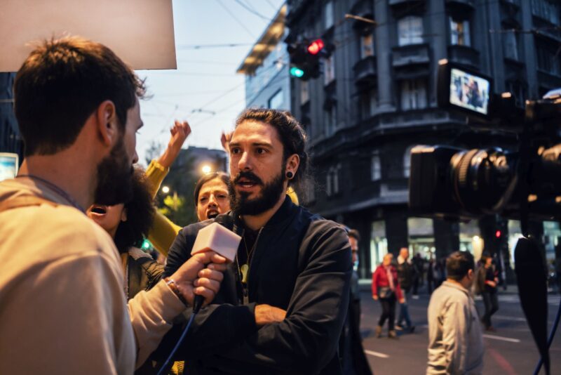 Picture Writing Prompts: Interview Man being interviewed by a reporter in the street