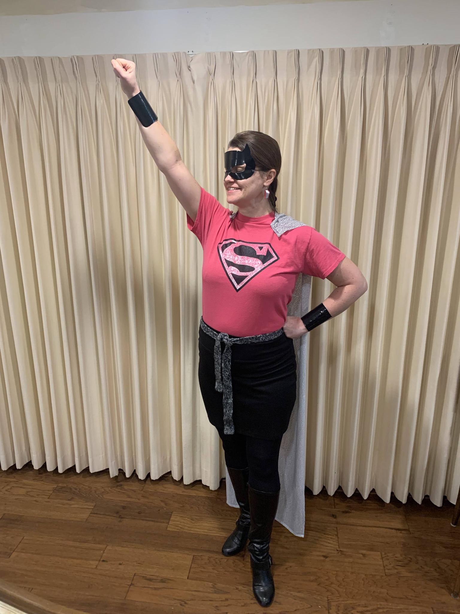 Teacher dressed as Super Reader, wearing a cape made of material that looks like book pages