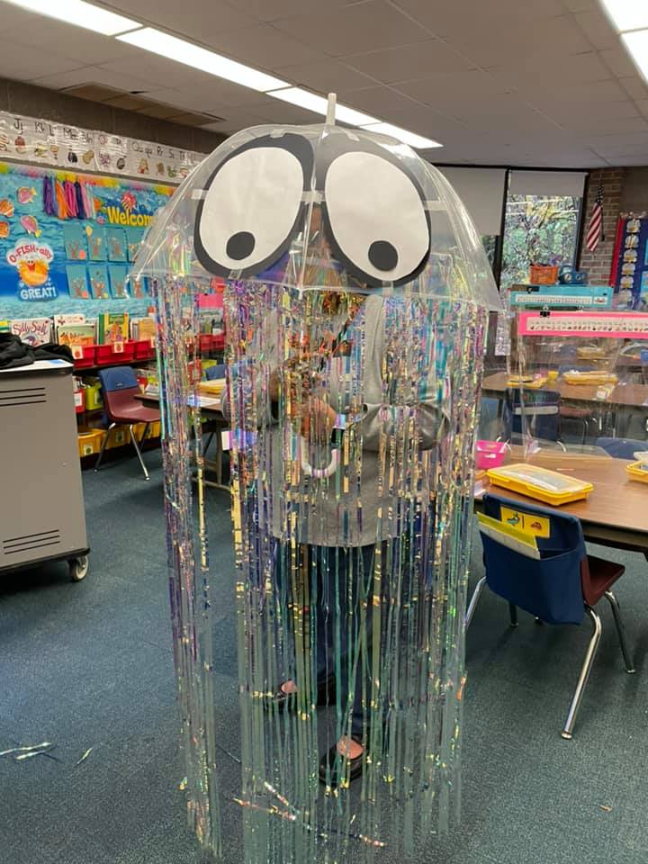 Teacher dressed as a jellyfish, carrying a clear umbrella with streamers attached