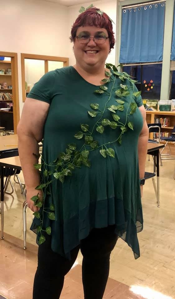 Teacher wearing a green dress with vines wrapped around it to be Poison Ivy for Halloween