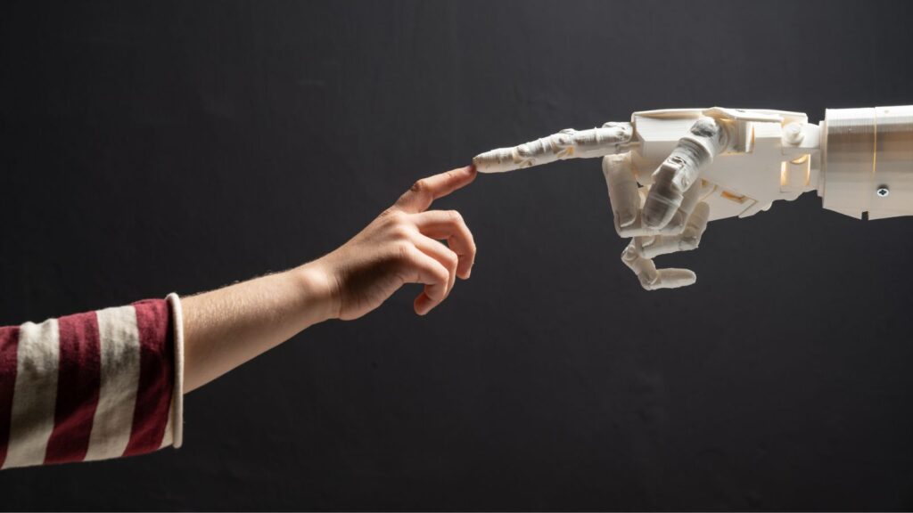 Photo of robot hand meeting child hand to illustrate the challenges of AI in schools
