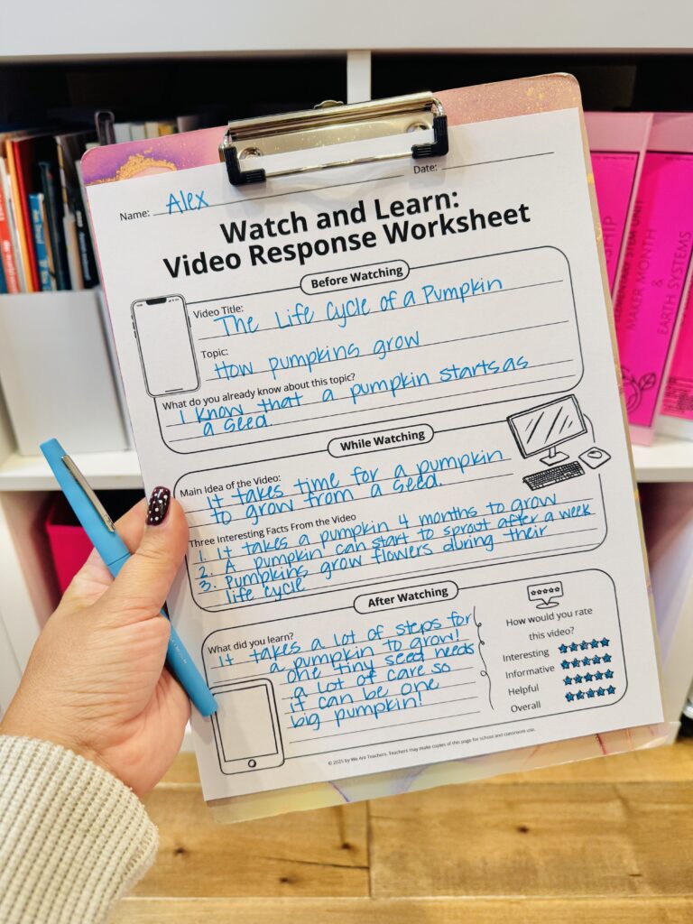 free video response sheet printable on a clipboard being help up by a person who also has a blue pen