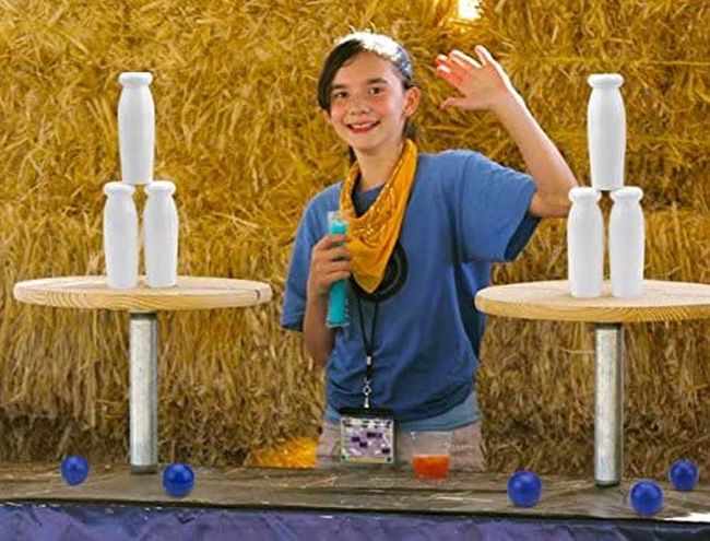 Carnival Games: Milk Bottles Child posing with stacked milk bottles and small balls for carnival games